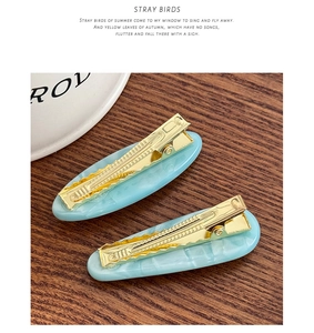 Detail of sky blue marble pattern hair clips with sturdy golden metal duckbill base