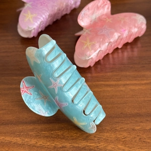 Three-piece colorful starfish hair claws in blue, pink, and purple marble finish