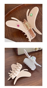 Détail de la pince à cheveux papillon en acétate avec strass colorés sur support bois
