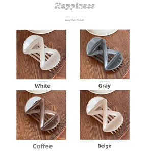 Close-up of elegant bow hair clips in four neutral colors on a dark wooden background