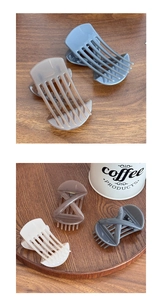 Close-up of minimalist cross bow hair clips in grey, mocha and cream matte finishes