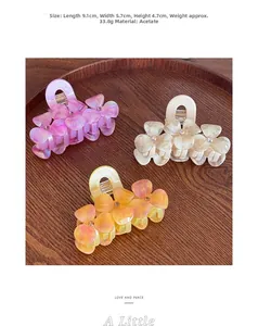 Detailed view of 3D acetate flower hair claws with rhinestone center on wood tray