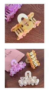 Detail of floral hair claws in lavender and ivory with delicate center rhinestone accents