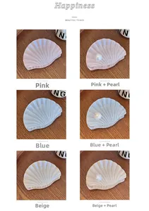 Vue détaillée des pinces à cheveux en forme de coquillage rose, bleu et beige à perles