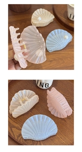 Détail de pinces à cheveux en forme de coquillage nacré avec perles et ressort métal