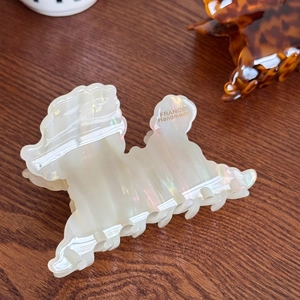 Elegant 3D poodle acetate hair claw clip with creamy pearlescent finish on wood background