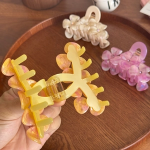 Three acetate flower claw clips with rhinestones in yellow, beige and purple colors