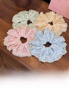 Dettaglio di quattro elastici per capelli a scacchi color macaron con perle bianche
