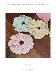 Dettaglio di elastici scrunchie a quadretti in tessuto con bordi di perle in tre colori