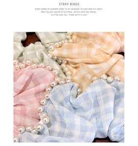 Dettaglio degli elastici scrunchie a quadri con eleganti perline in colori pastello