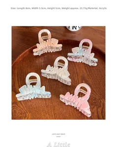 Macro detail of five multi-color acetate shark hair clips with marble texture in a tray