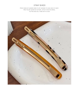 Macro shot of tortoiseshell acetate hair clips with detailed gold metal clip lettering