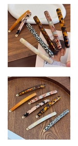 Close-up of slim tortoiseshell acetate hair clips with gold metal spring fasteners
