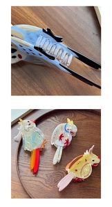 Detailed view of parrot-shaped acetate hair claws with iridescent pearlescent finish