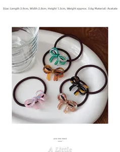 Detail view of five assorted acetate bow hair ties arranged on a white decorative plate