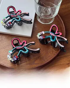 Close-up of hair claw clips with colorful wave patterns and sparkling star rhinestones