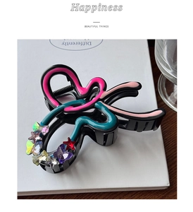 Detail of colorful drip oil bow hair claw clip with colorful butterfly charms on magazine