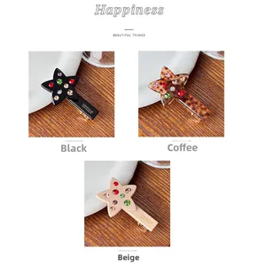 Detail of star-shaped hair clips in black, brown, and beige with colorful rhinestones