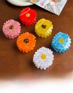 Detailed close-up of six colorful daisy flower hair claws in a high-quality acetate finish