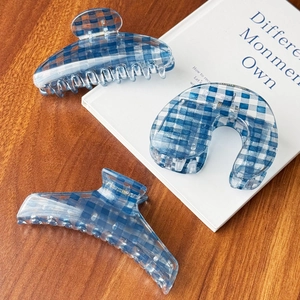 Pinze per capelli a quadretti blu e bianchi in varie forme su un tavolo di legno
