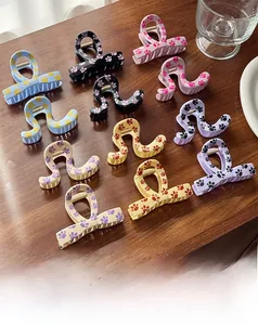 Close-up of assorted medium hair claws with cute paw prints on a wooden surface