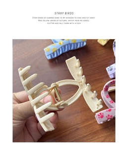 Detailed view of the durable gold metal spring and cute paw print on the matte hair claw