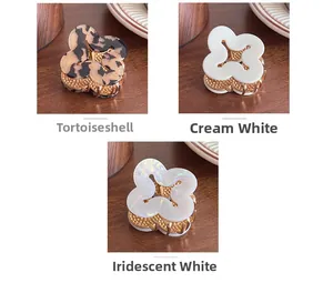 Detailed view of hollow flower hair claws in beige tortoiseshell, cream and pearl white colors