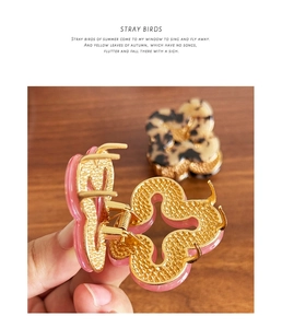 Detail of pink glossy and leopard print flower hair claws on golden alloy frame