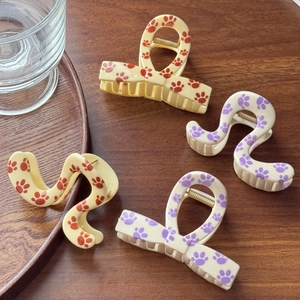 Medium acetate claw clips with cute paw prints in bow and wave shapes on wood background