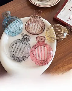 Detail of marble pattern jelly hair claws in blue amber and pink on white tray