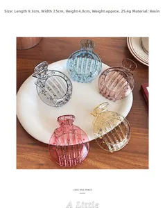 Detail view of five round hollow hair claws in jelly colors on a ceramic tray
