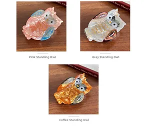 Detailed close-up of owl hair clips in pink, pearl grey, and amber acetate with rhinestones