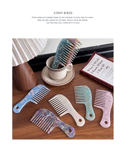 Detail of wide-tooth acetate hair combs with marble patterns on a wooden table