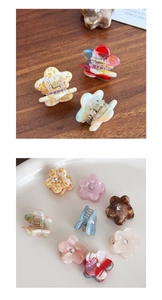 Close-up of floral acetate mini hair claws with rhinestone center in varied colors
