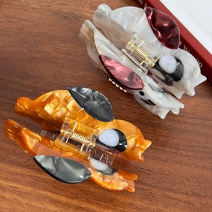 Creative owl hair claws in amber orange and pearl white with elegant marble texture