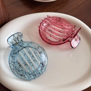 Ink line art hair claws in translucent ice blue and rose pink resin on ceramic tray