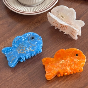 Fish shaped acetate shark hair clips in blue, orange, and white marble textures