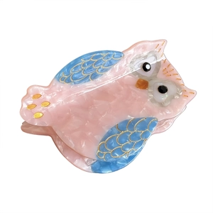 Pink and blue marble owl hair claw clip with gold accents on a white background
