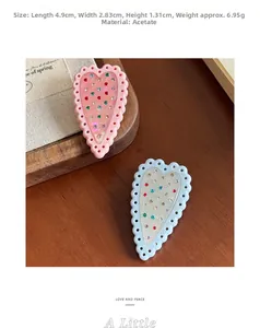 Vista dettagliata della molletta a cuore in acetato con strass e misure delle dimensioni
