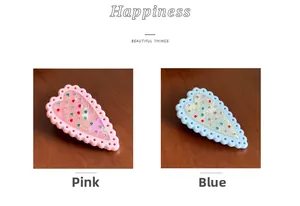 Dettaglio di fermagli per capelli a cuore con strass colorati in rosa e blu
