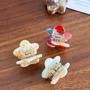 Mini floral acetate hair clips with crystal accents and gold spring on wood background