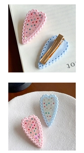 Dettaglio di fermagli per capelli a forma di cuore rosa e blu con strass colorati e clip
