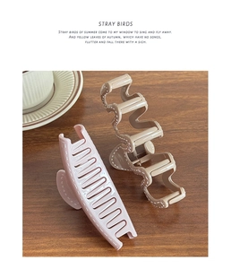 Détail de pinces à cheveux rose et beige avec motif de pointillés sur table en bois