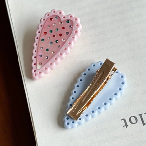 Fermaglio per capelli a cuore rosa con strass colorati e clip a becco d'anatra su carta