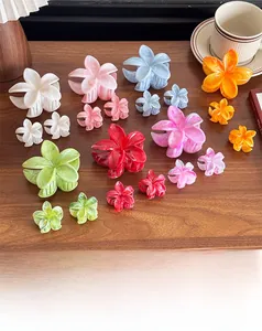 Detailed close-up of colorful frangipani hair claws with elegant marble texture finishes