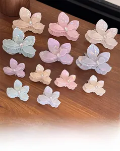 Detailed set of iridescent flower hair claws with rhinestones on a wooden surface