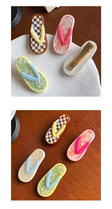 Macro detail of flip-flop shaped acetate hair clips with checkered and marble patterns