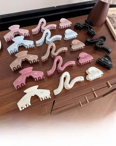 Detailed overhead view of assorted matte hair claws with heart patterns on wooden surface
