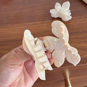 Elegant iridescent butterfly hair claw clip with pearlescent finish and crystal detail