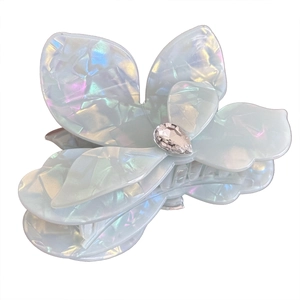 Iridescent flower petal hair claw clip with large teardrop rhinestone on white background